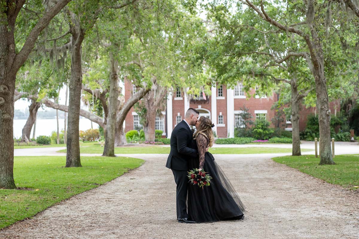 South Sarasota wedding venue with bride and groom kissing under an arch of trees