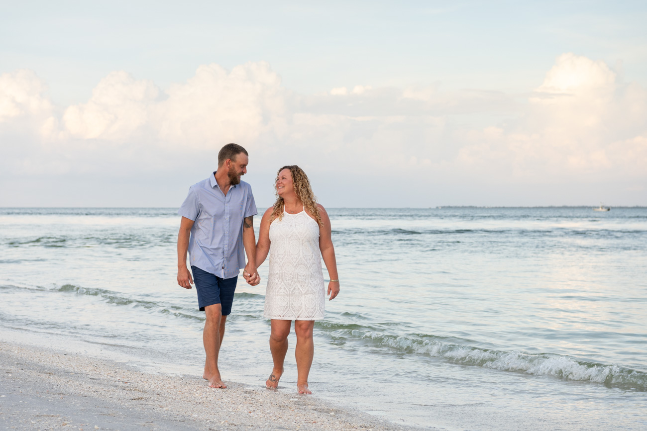 couple walking along beach while holding hands