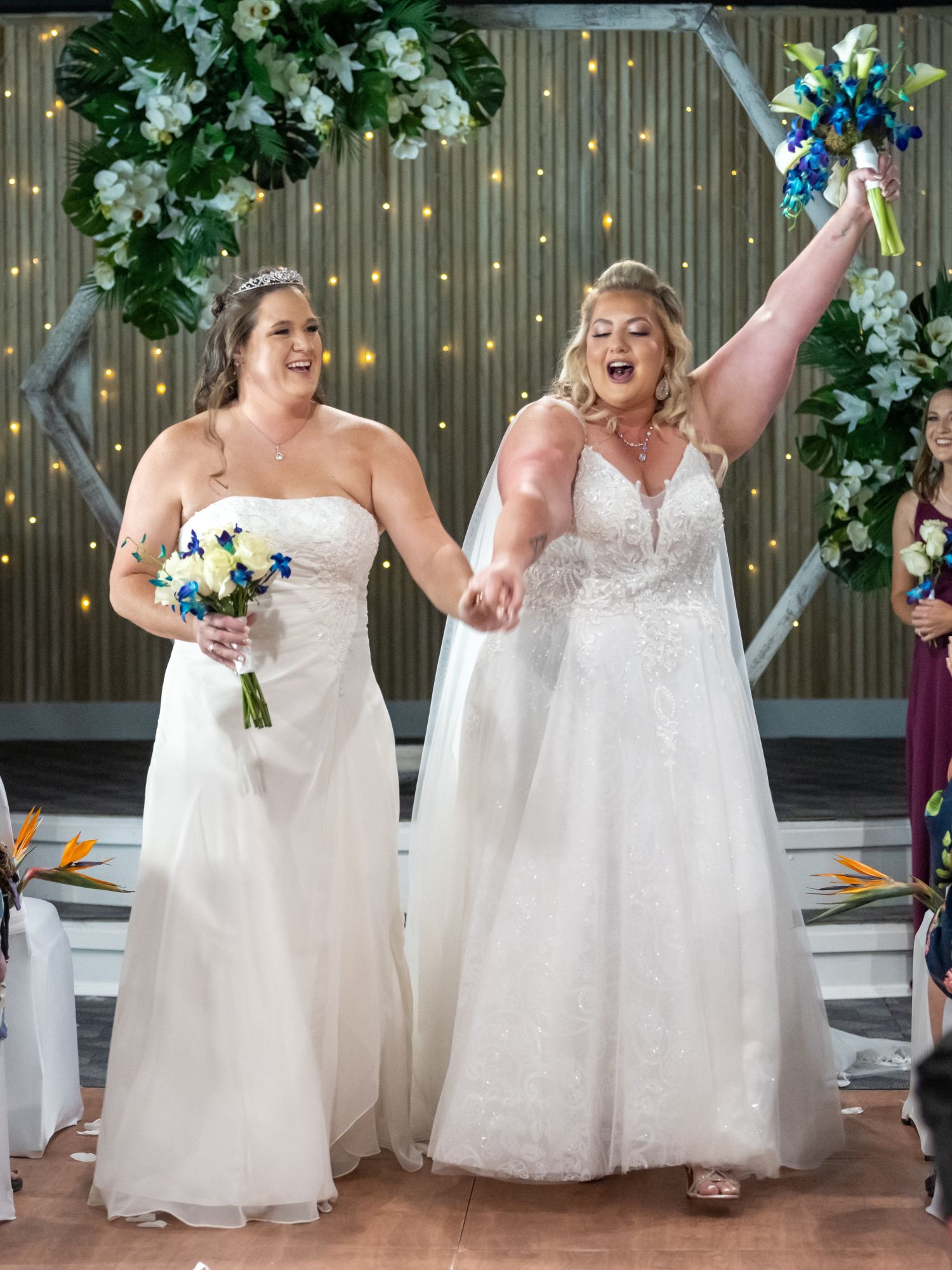 two brides celebrate after saying their vows at the alter