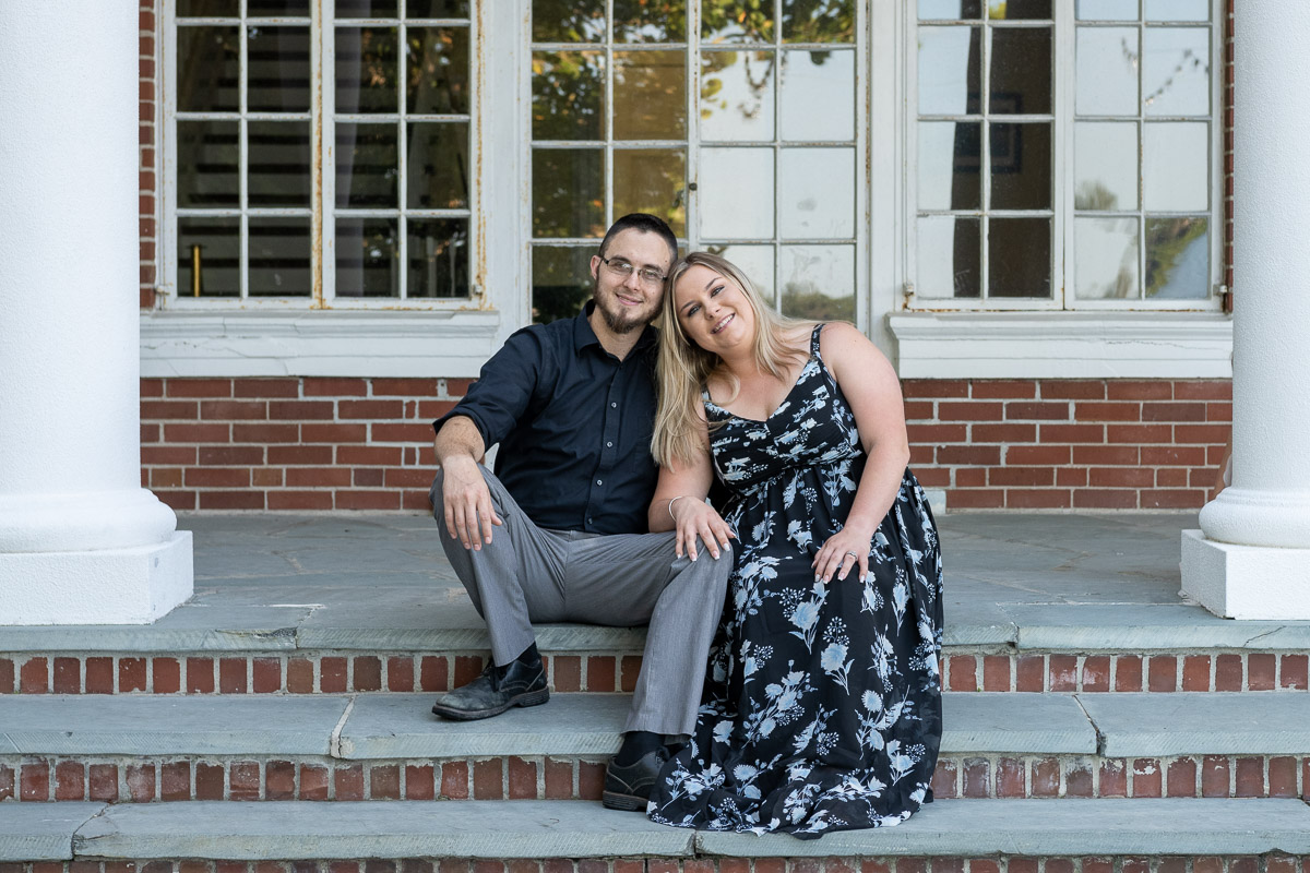 engaged couple sit on the steps