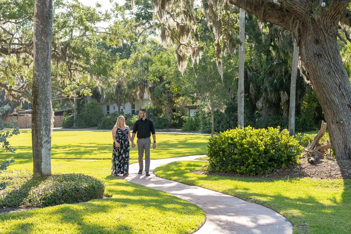 couple walk along the path at Bay Preserve at Osprey holding hands