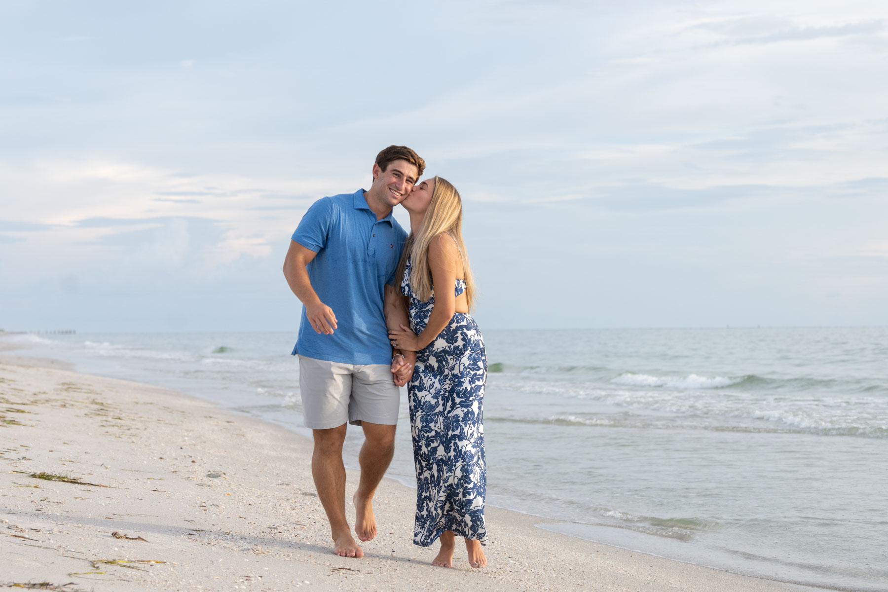 Hannah leans over to kiss Will's cheek as they walk along the beach on Boca Grande