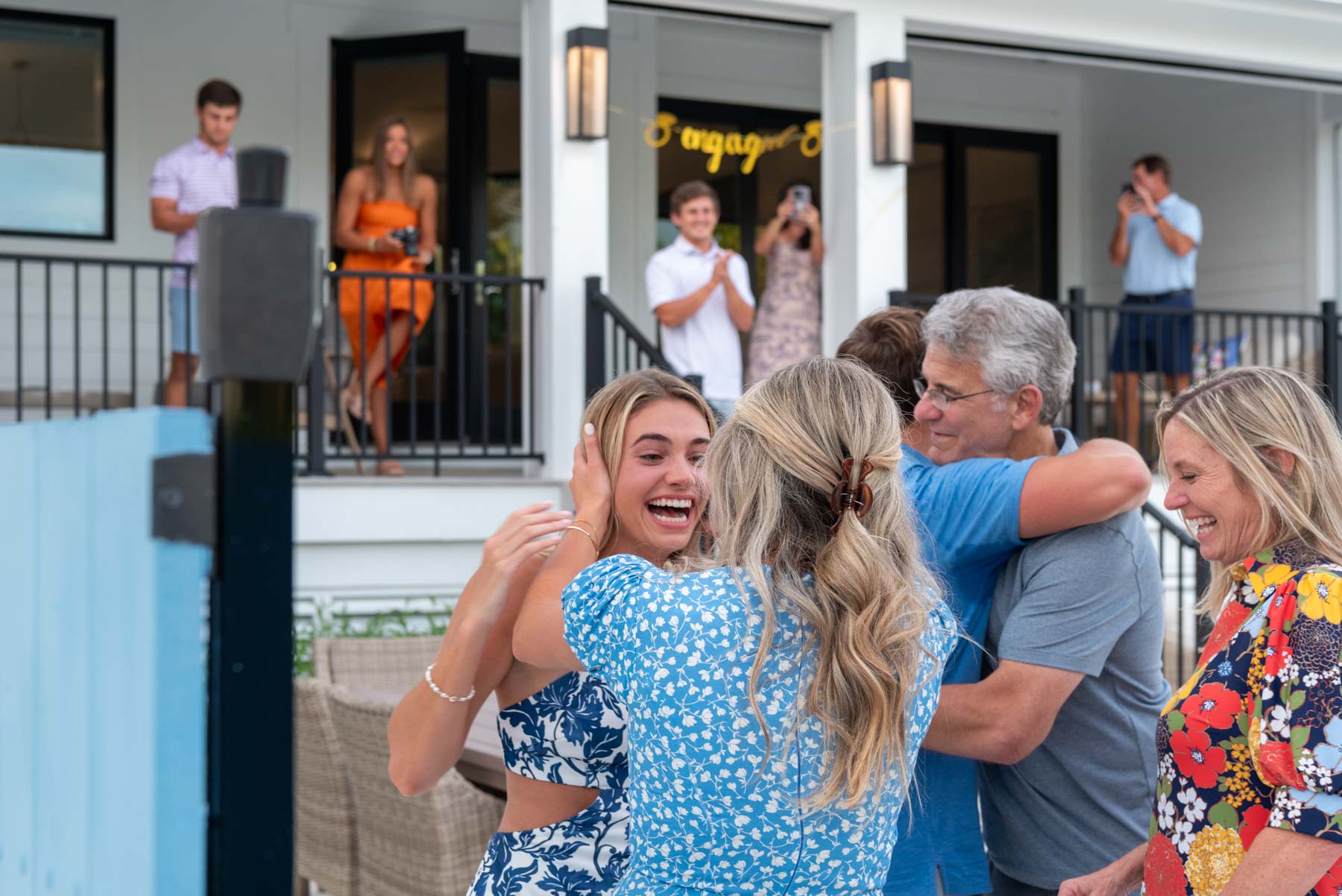 family hugs and celebrates the couple's engagement