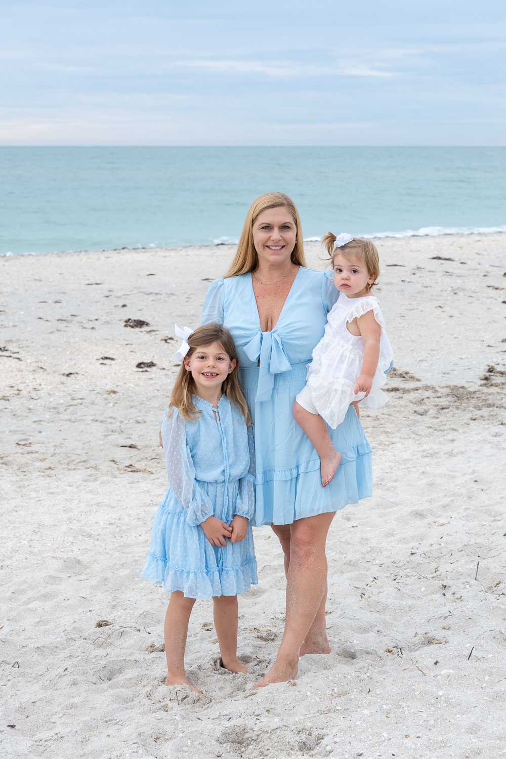 mom and her two daughters dressed in blue on beach at Casey Key