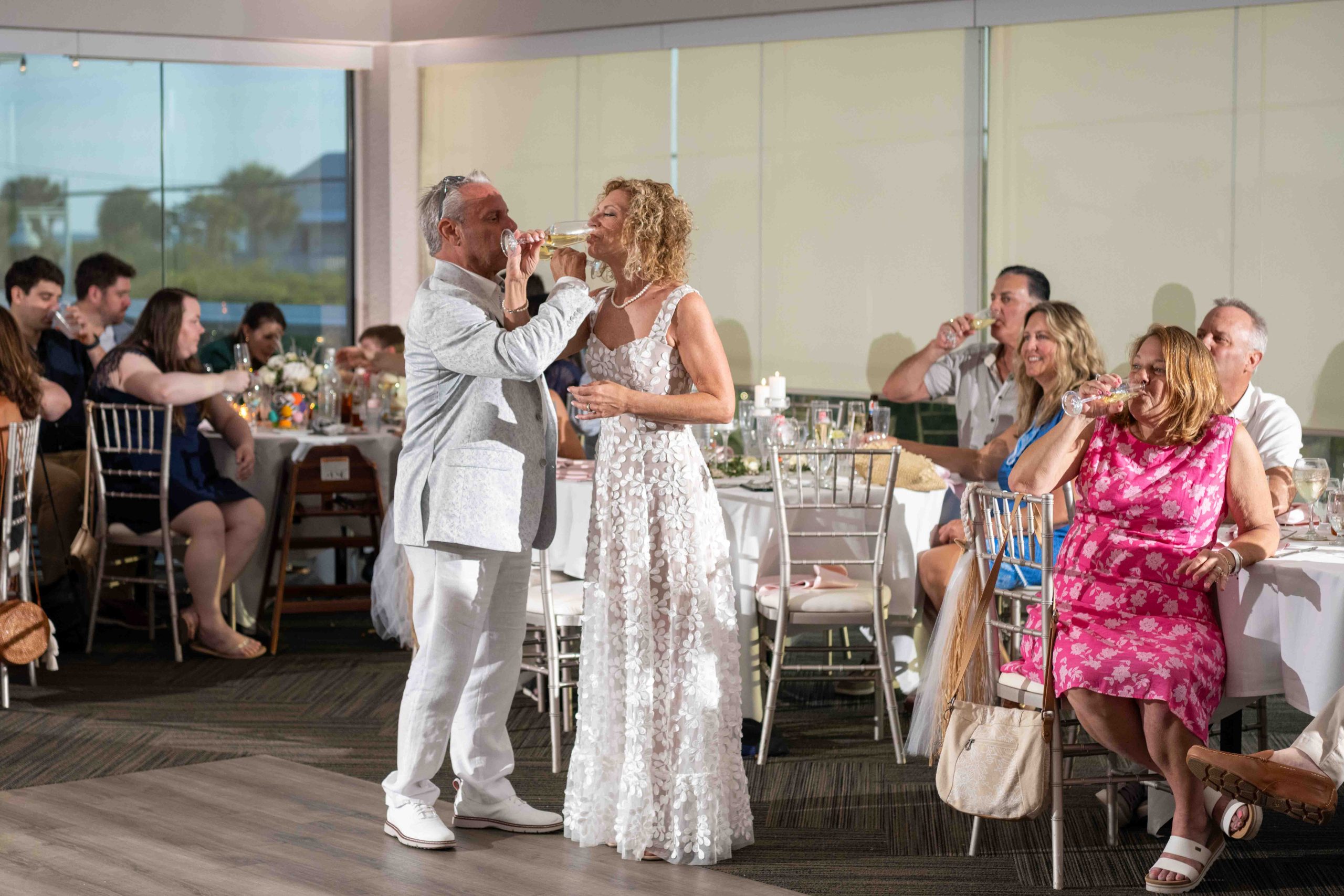 bride and groom intertwine arms and drink champagne at The Waverly on Manasota Key