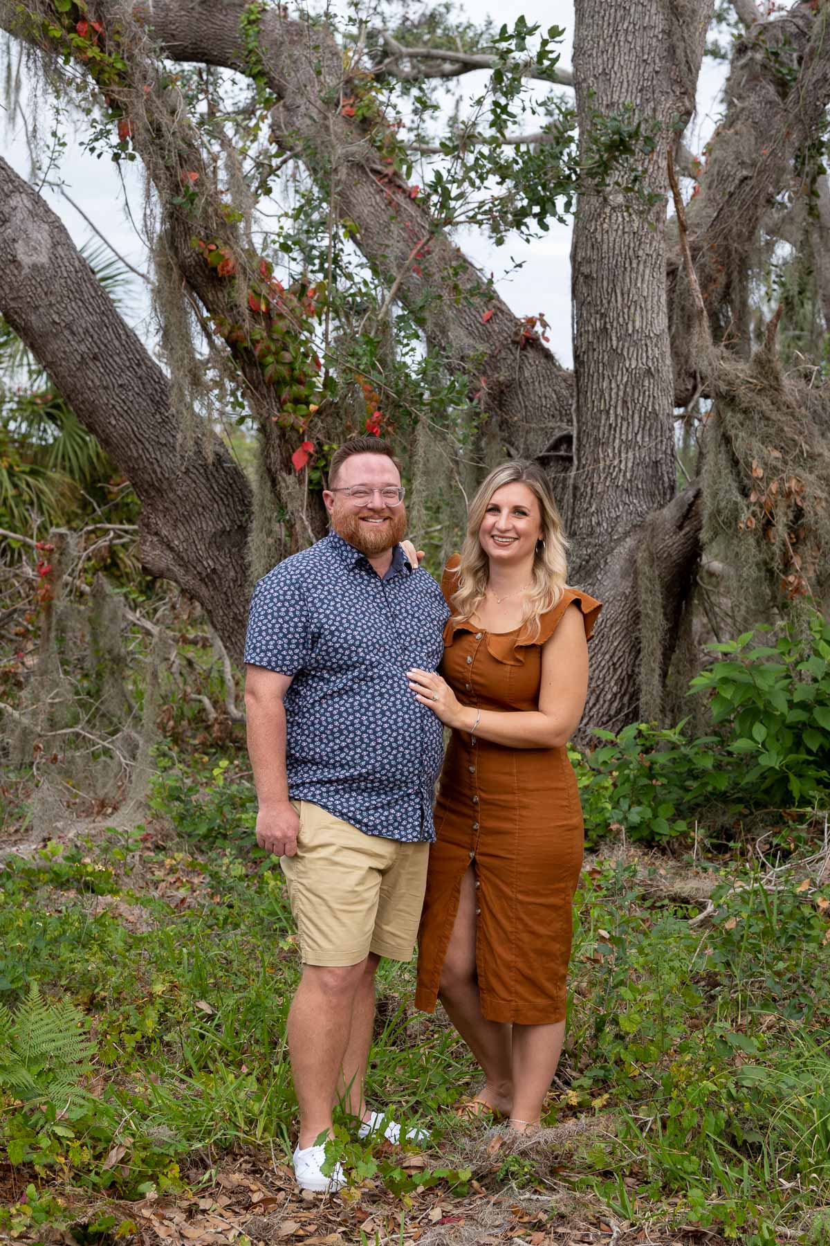 couple standing in front of a large tree during their Lemon Bay Park engagement session