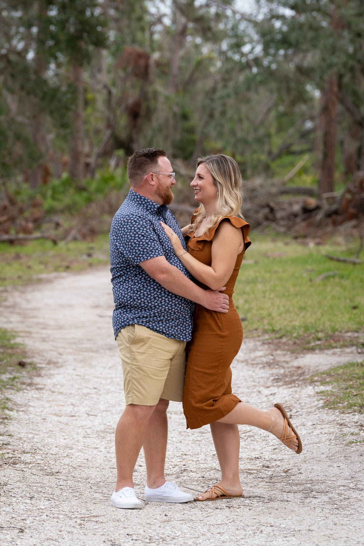 man and woman facing each other on a trail in the woods