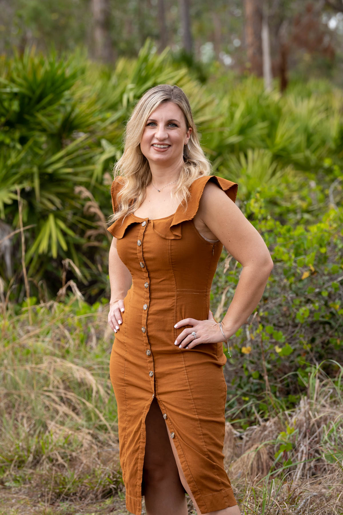 woman strikes a confident pose surrounded by trees
