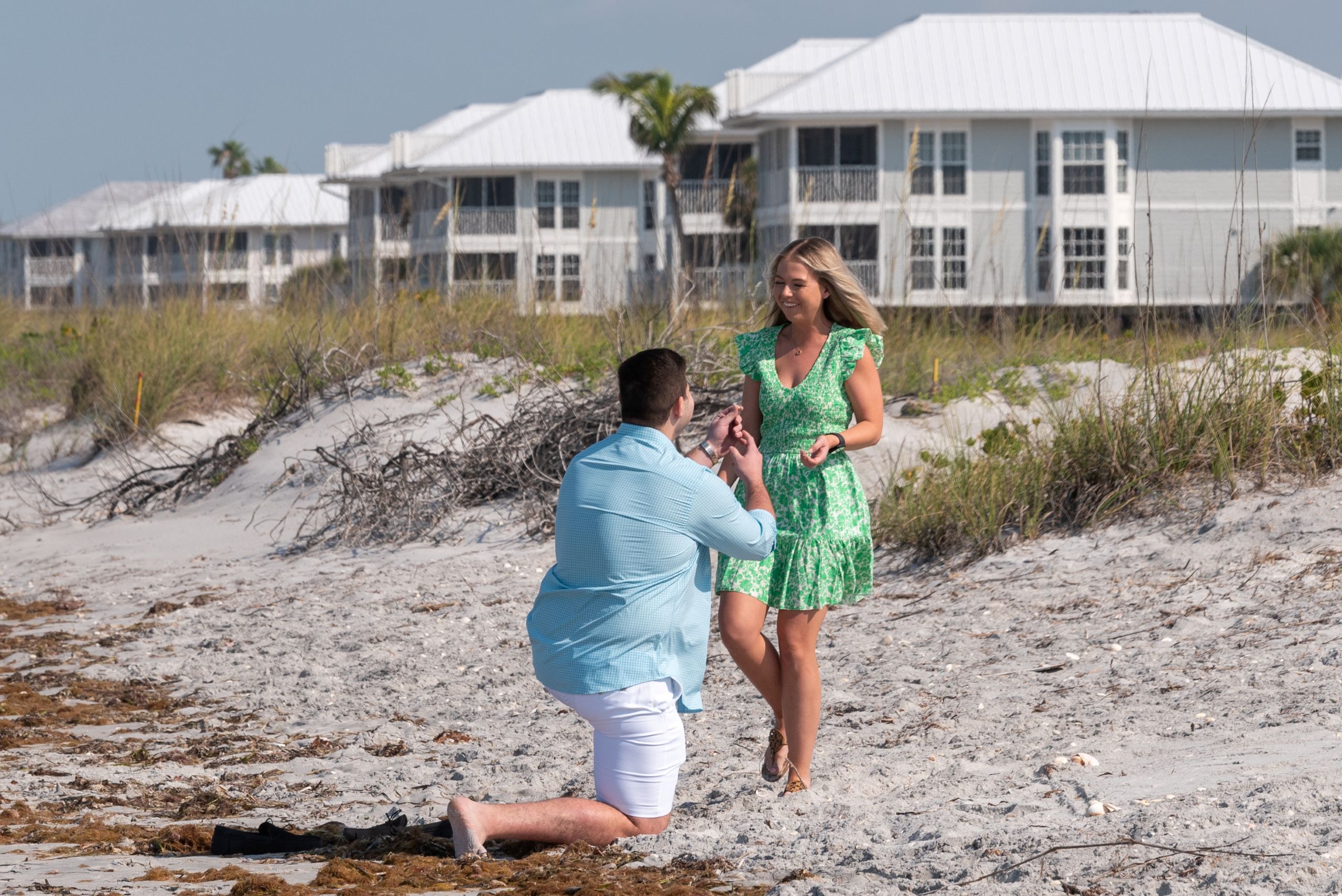 man gets down on his knee to show his girlfriend an engagement ring and proposes to her