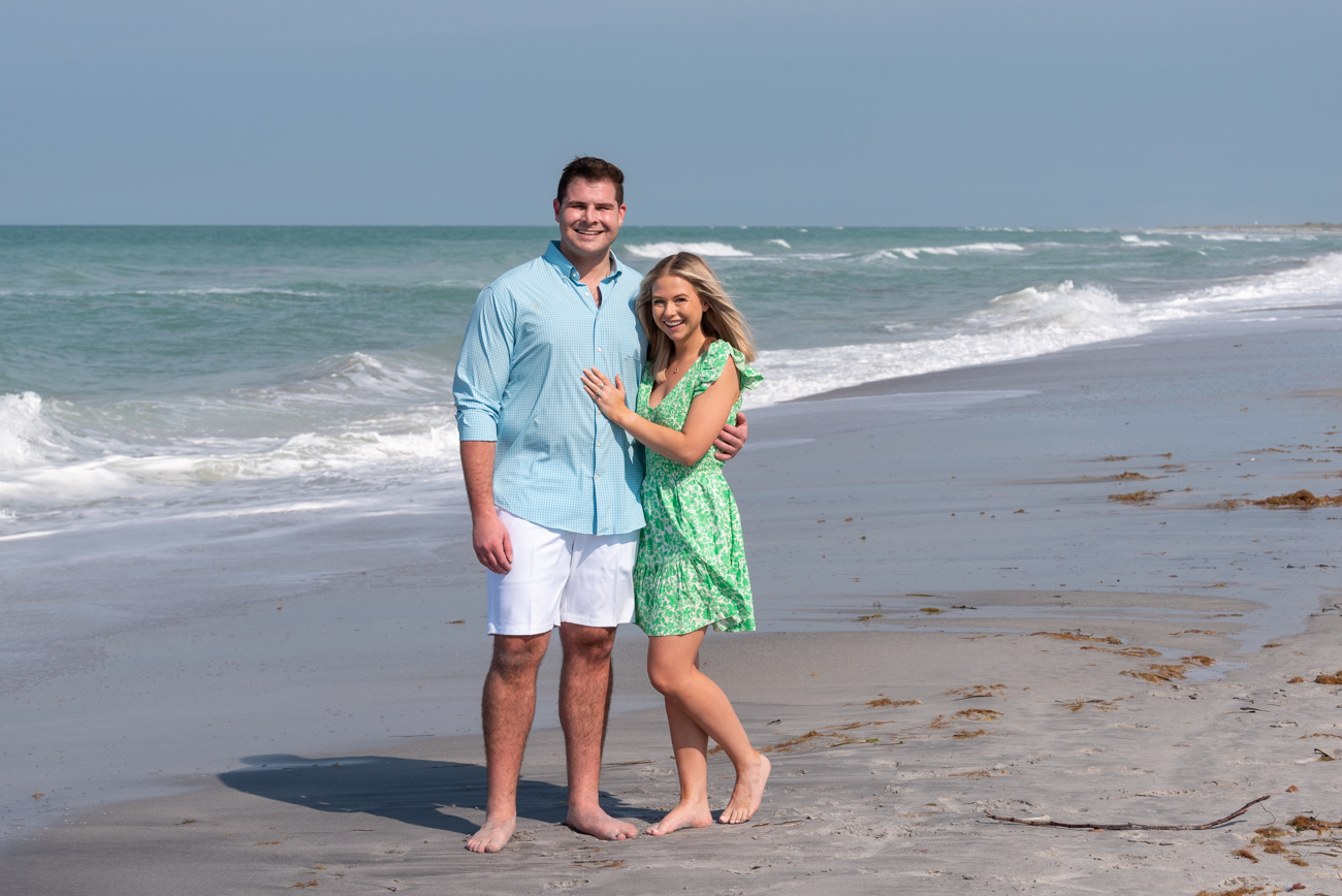 girl puts her hand with her new engagement ring on her fiances chest