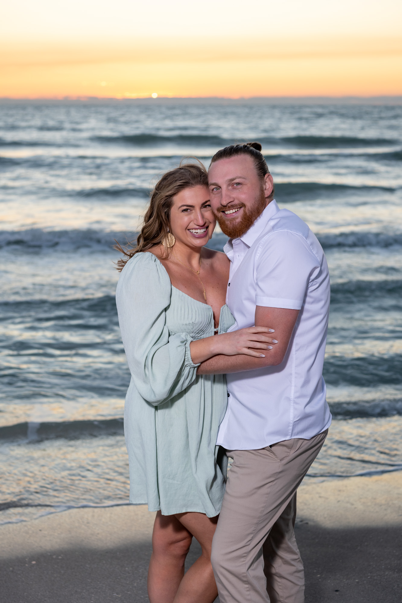 engaged couple smile in excitement during their Englewood beach engagement session on Manasota Key