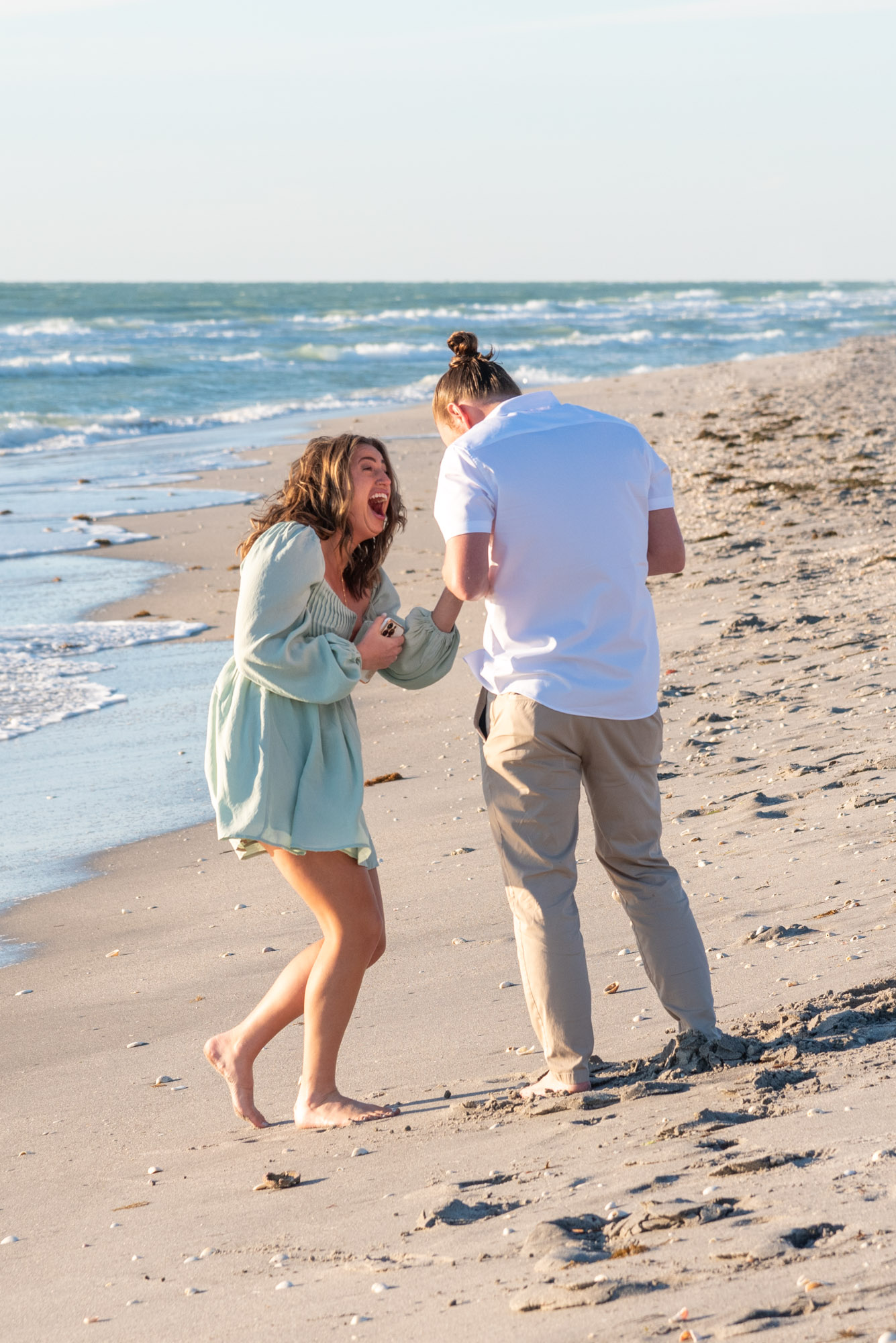 girl is in shock as boyfriend looks at her ring on her finger