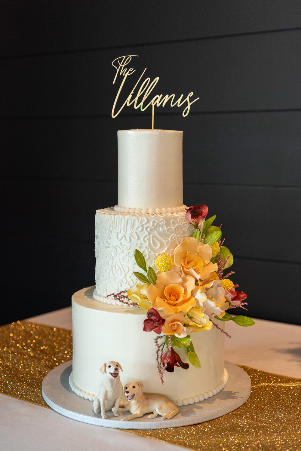 three tiered white wedding cake with yellow flowers