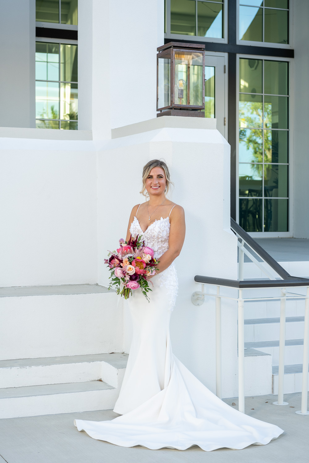 bride holds her wedding bouquet as she stands in front of Solis Hall