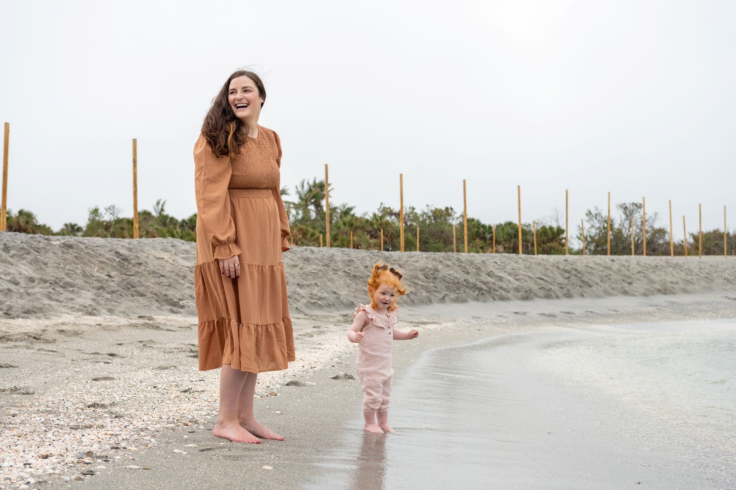mom laughs as she watches her daughter as the water line