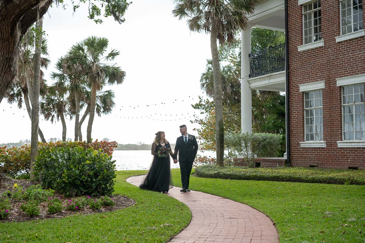 the bride and groom walk along the brick path at Bay Preserve
