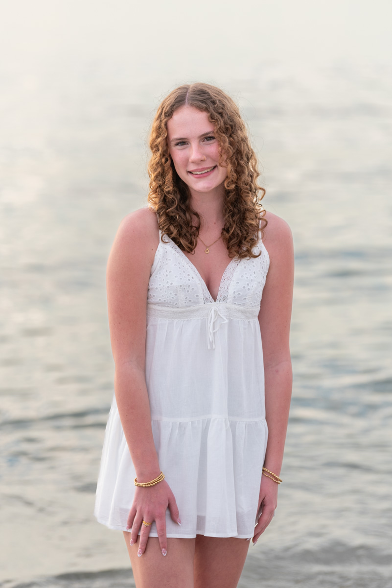 senior session with girl in short white dress standing in the water