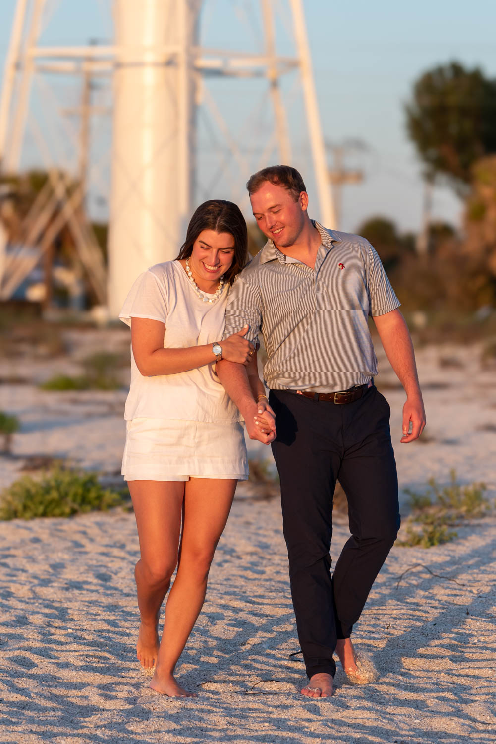 girl hugs her fiance's arm and smiles as she's giddy after the proposal