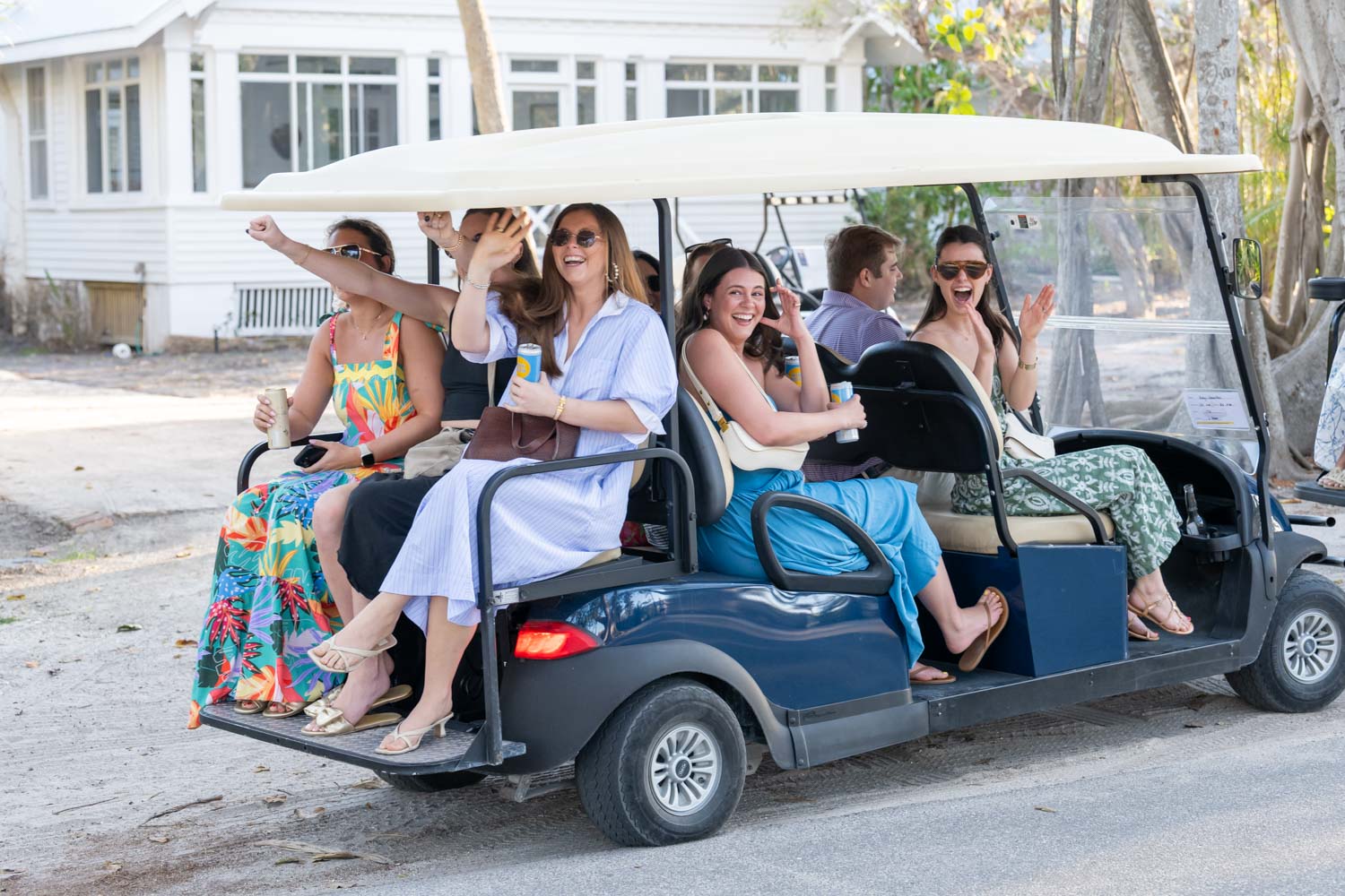 golf cart full of sorority sisters pull up as they excitedly cheer