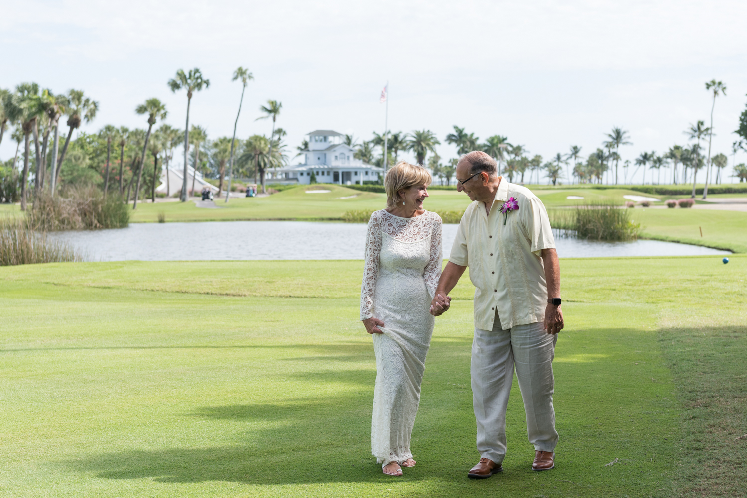 bride and groom on golf course holding hands