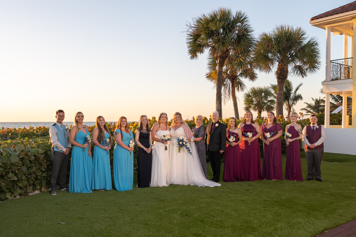 bridal party stands in front of palm trees outside of Casey Key Resort