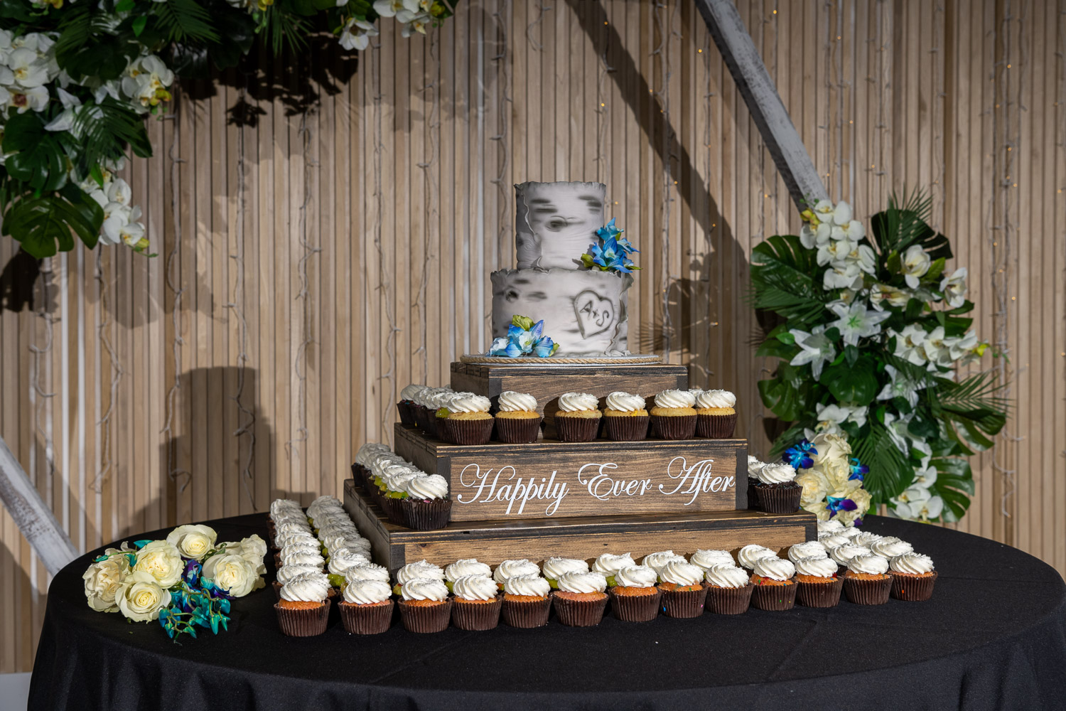 wedding cake and cupcakes on display