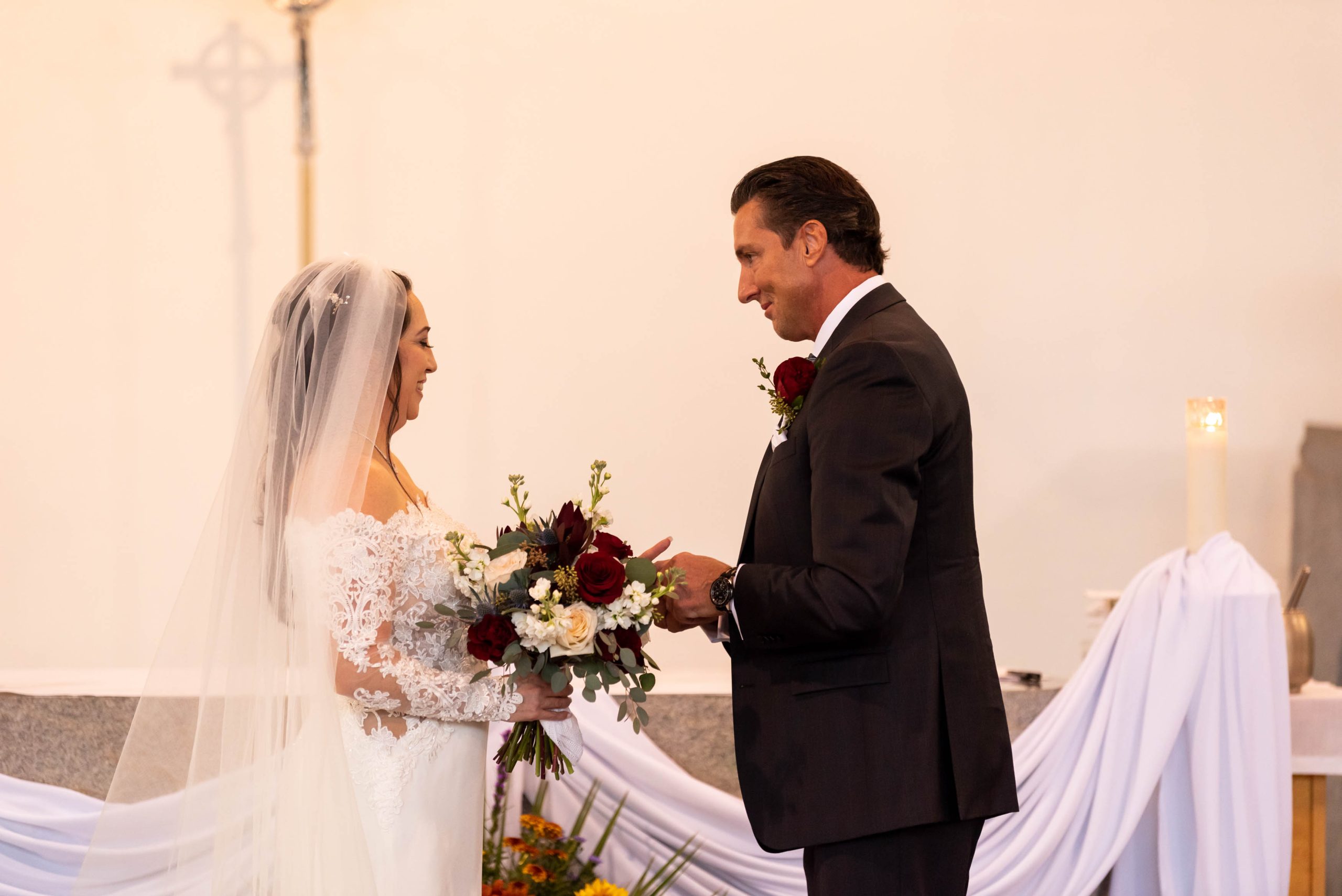 groom puts ring on brides finger
