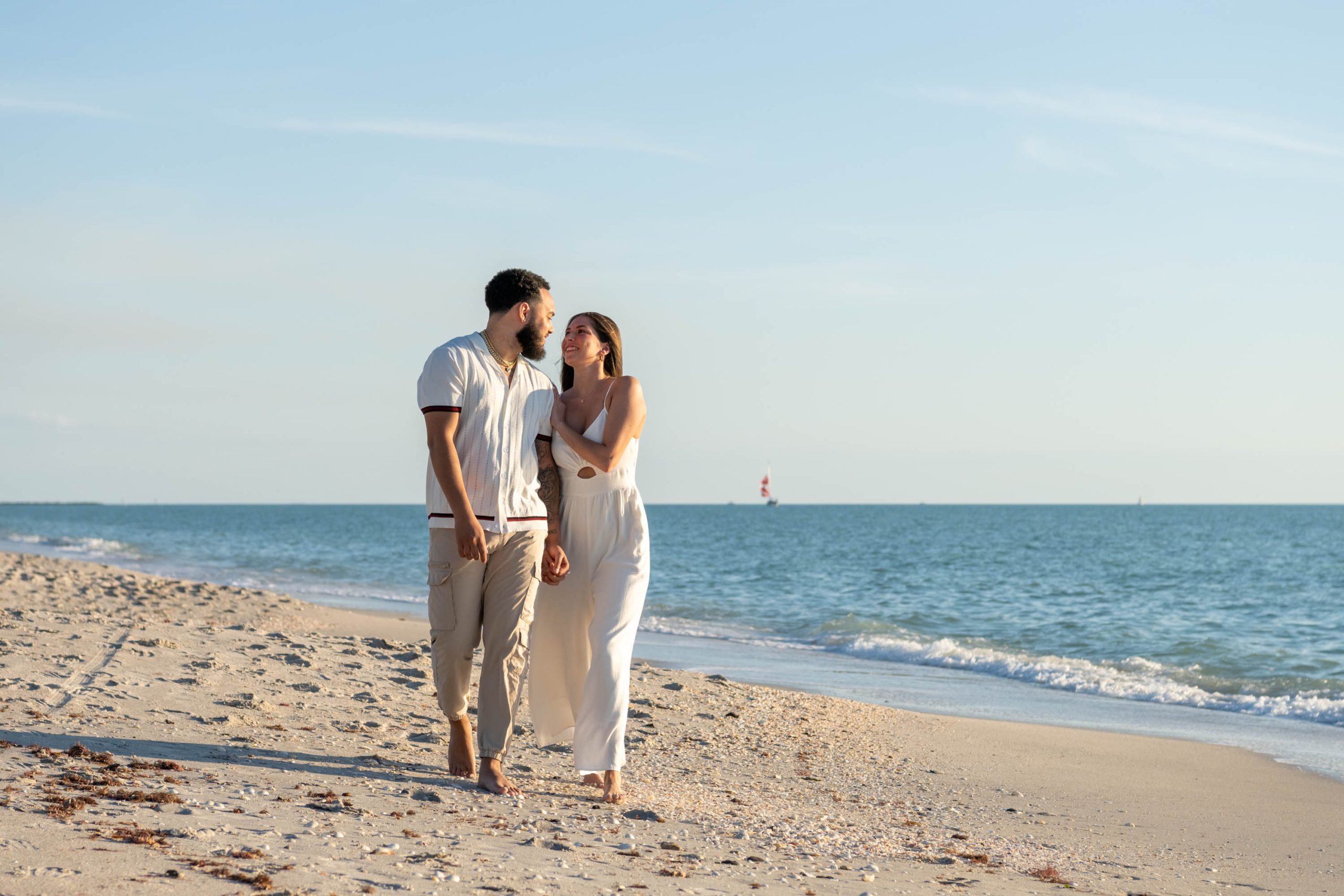 engagement session on Casey Key with couple walking along the beach