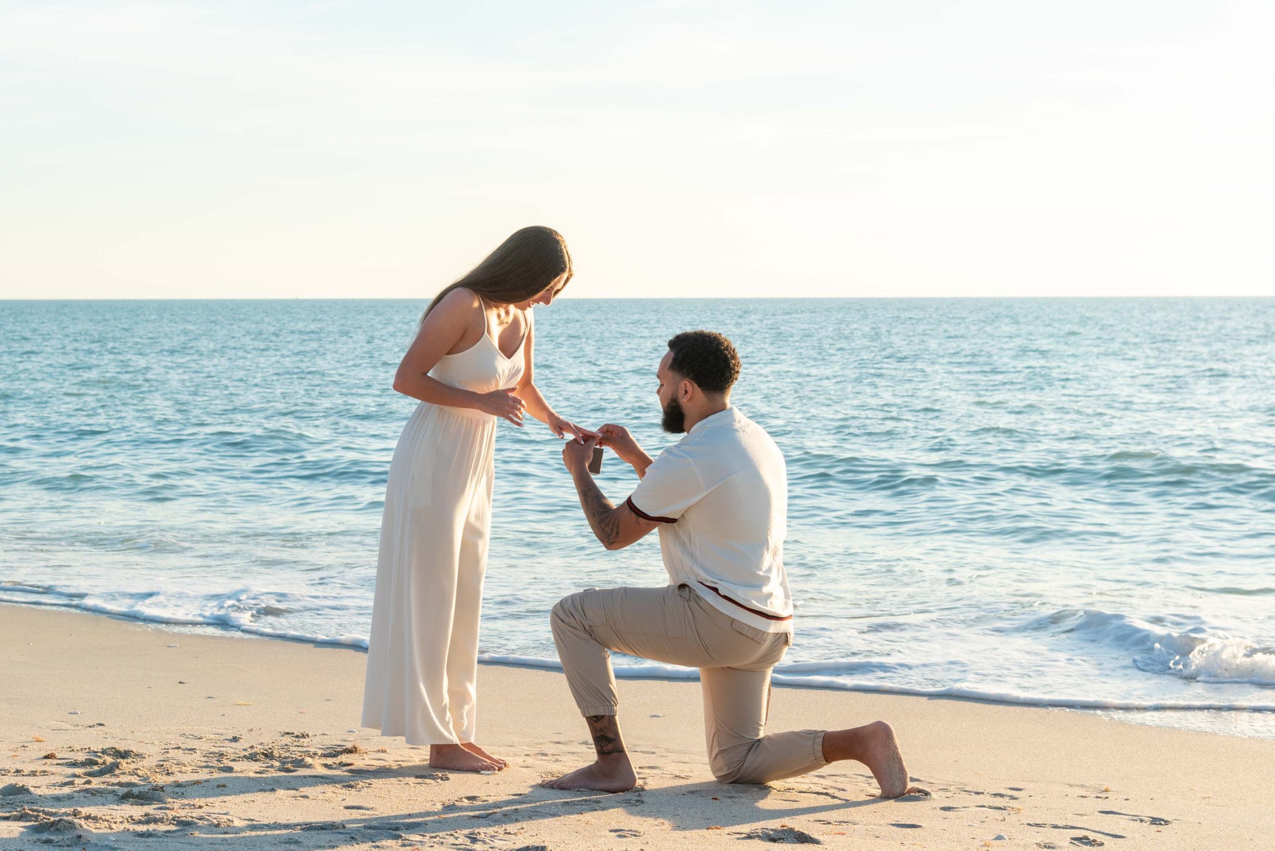 man puts engagement ring on his girlfriend's finger