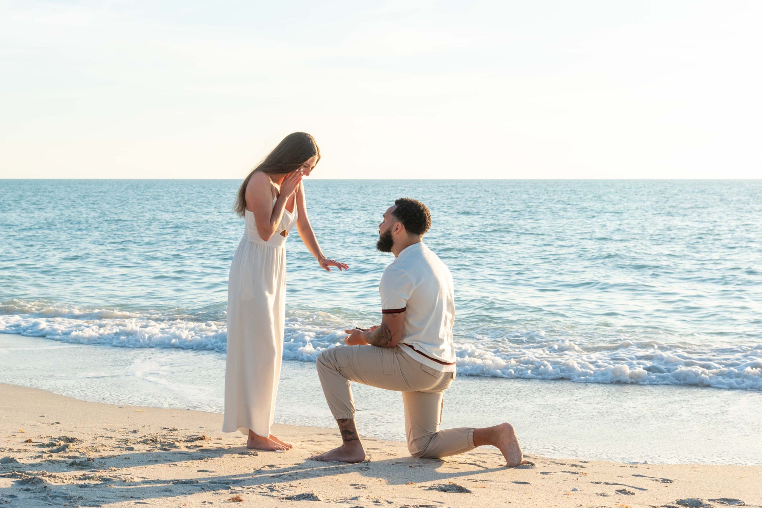 girl puts her hand out to accept engagement ring