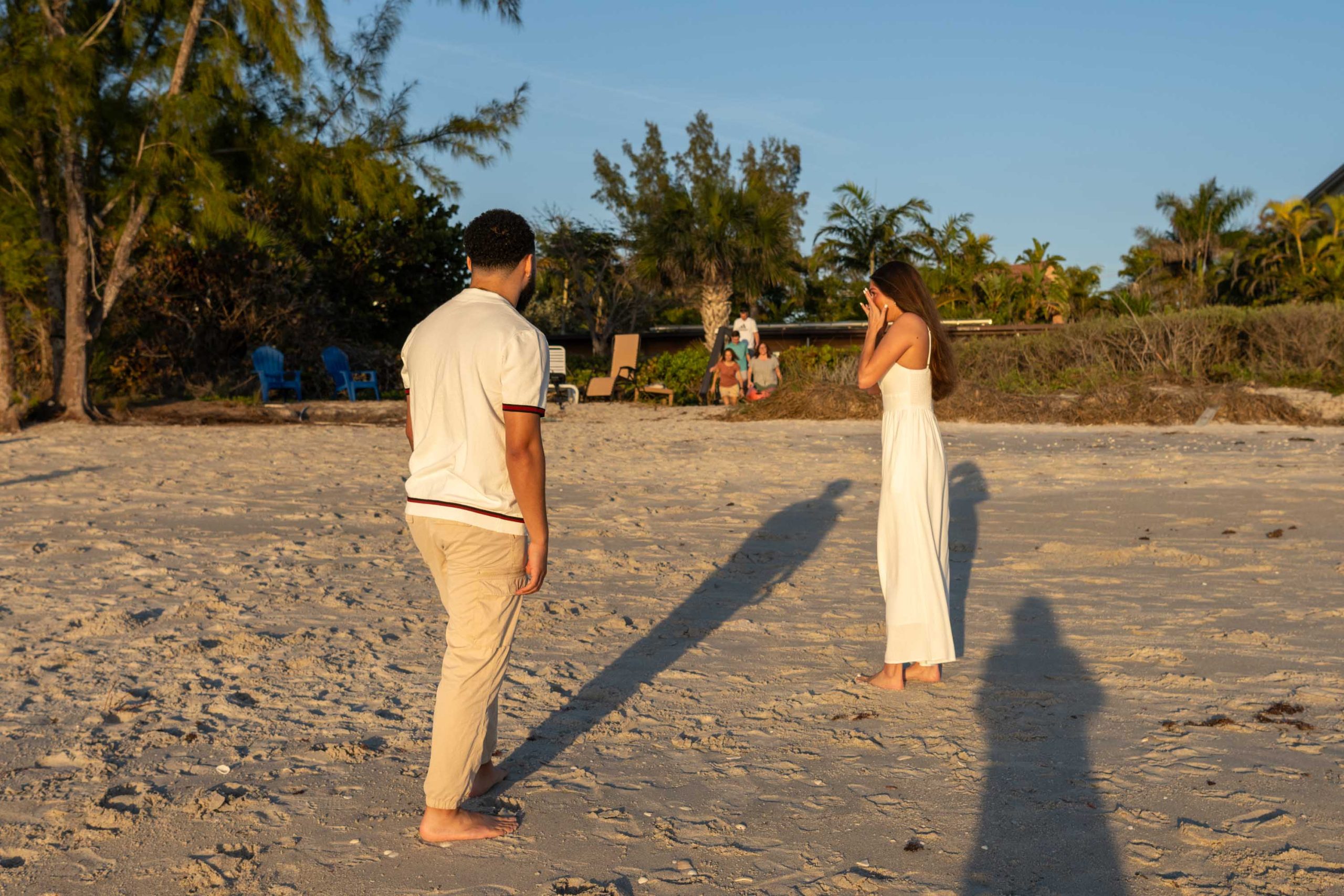 newly engaged couple turn to see their families approaching them