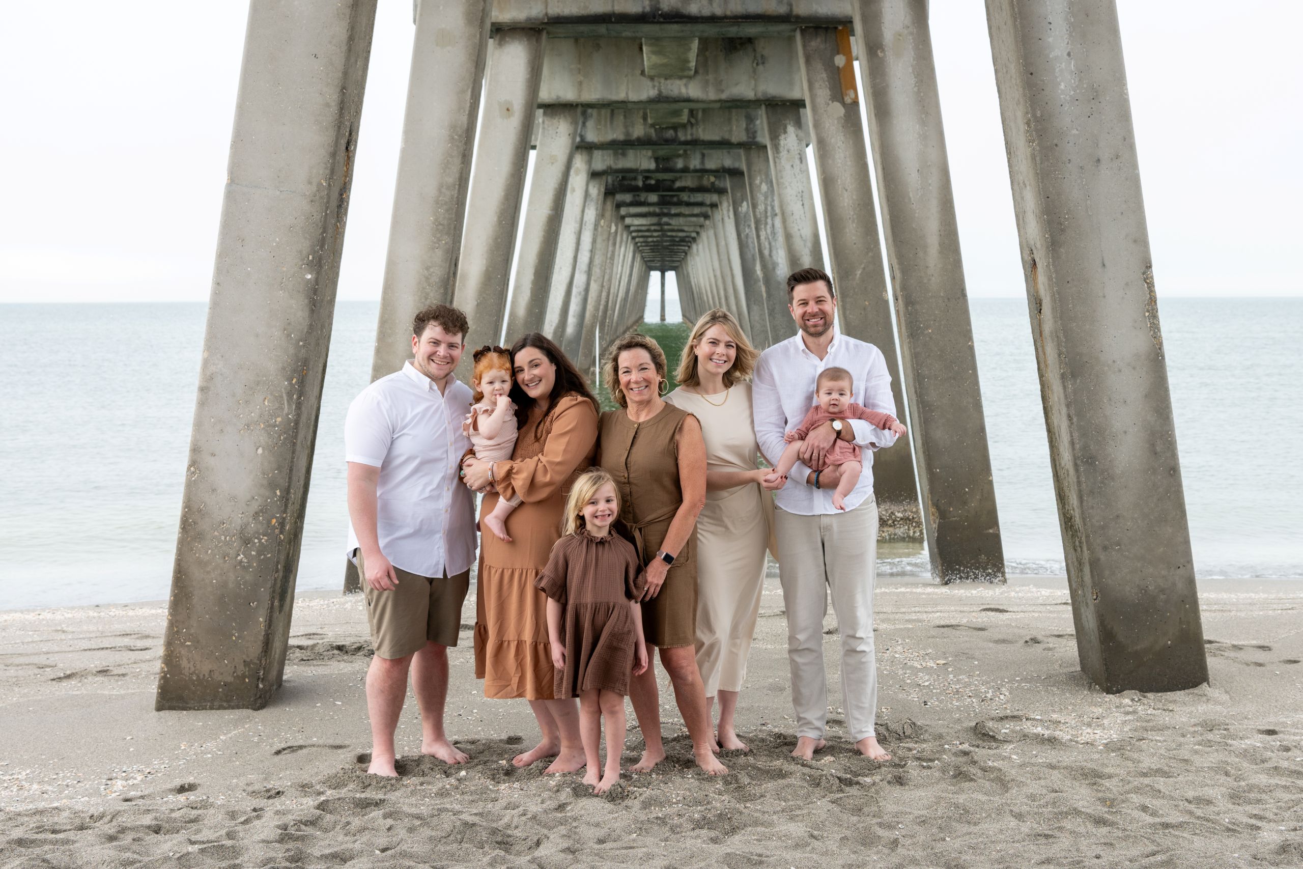 large family together under the Venice Fishing Pier during morning session