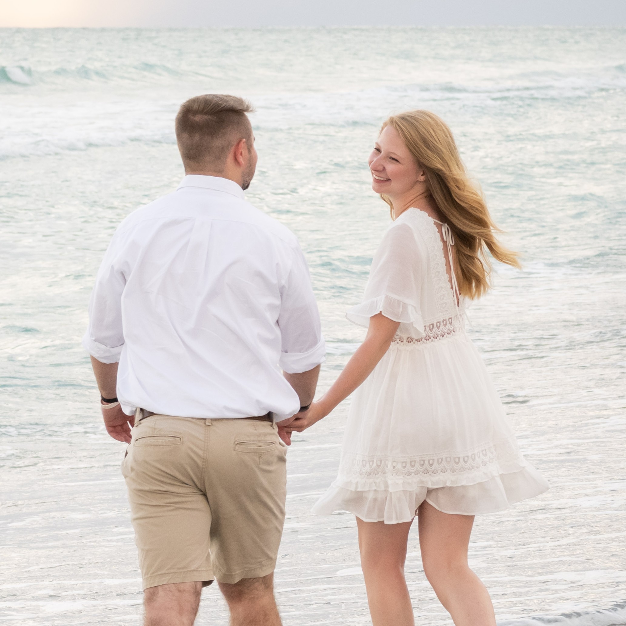girl smiles at boy as they play in the water