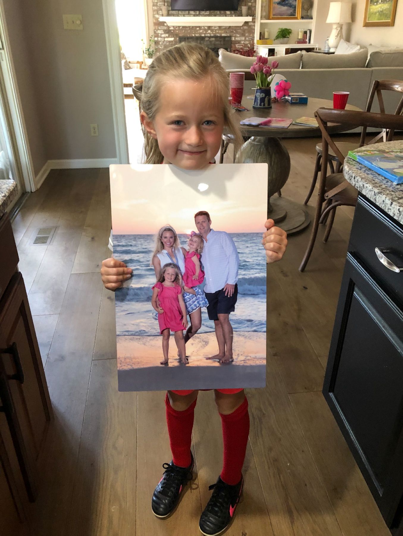 young girl holding metal picture of her family