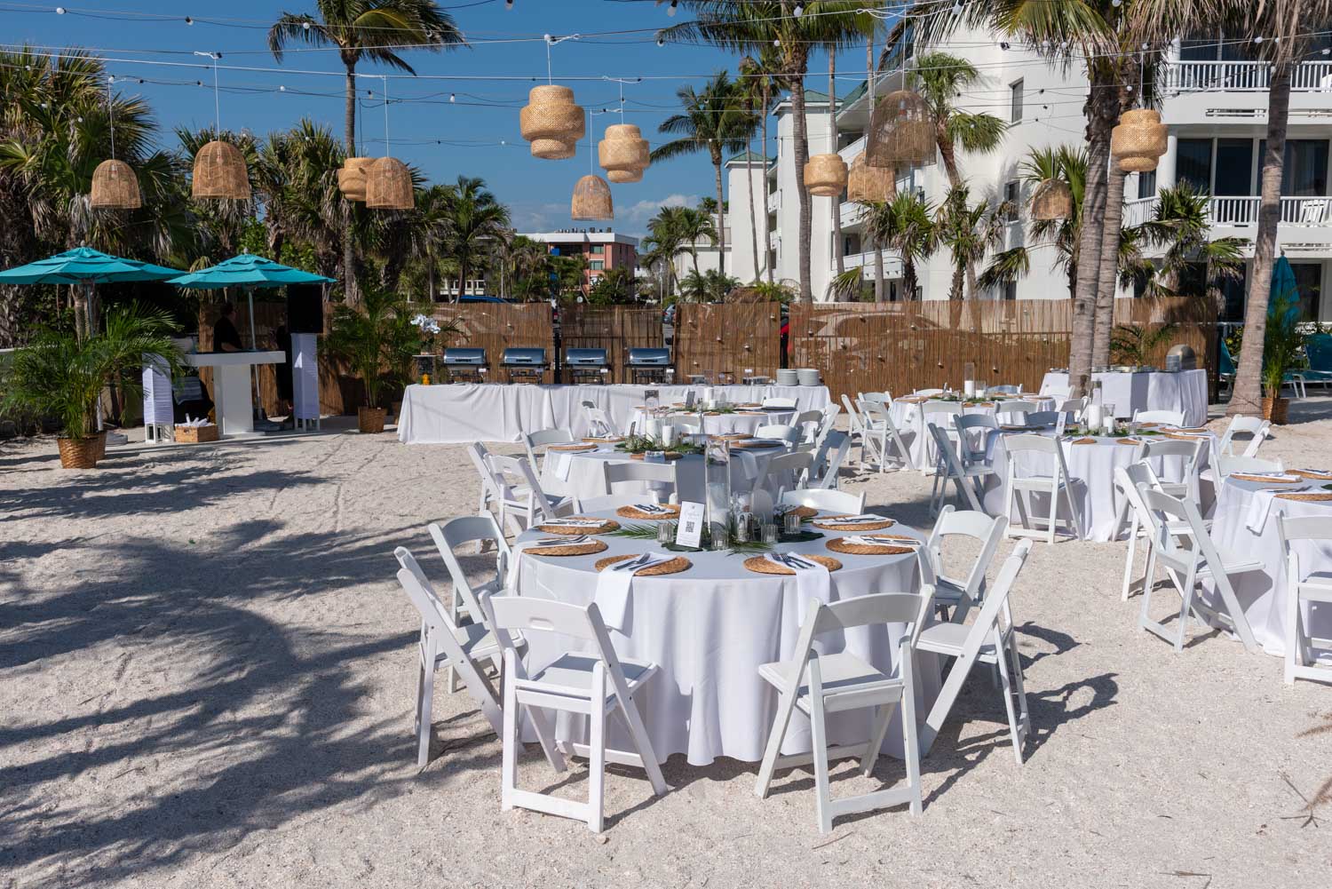 wedding reception at Lido Beach Resort with table, chairs and lanterns hanging among the palm trees
