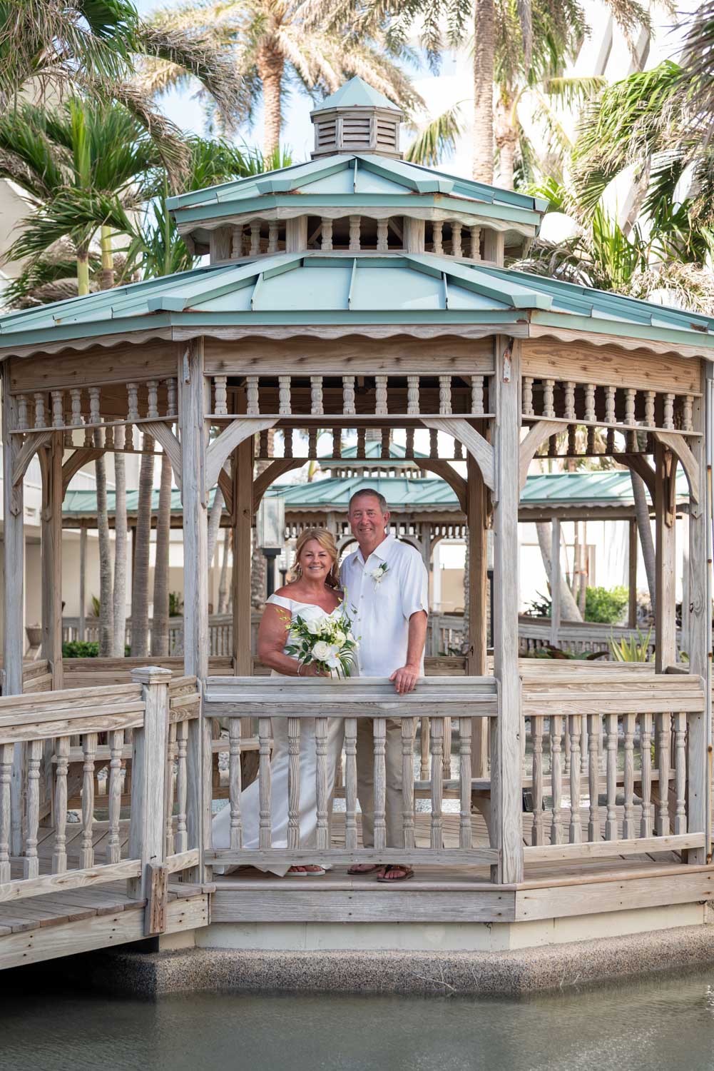 bride and groom under gazebo at Lido Beach Resort before their wedding