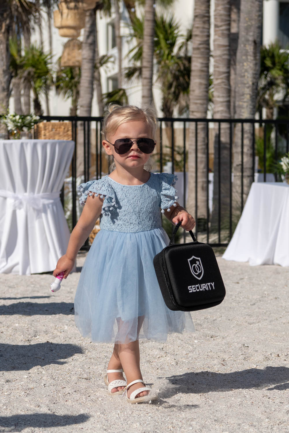 little girl as ring bearer wearing sunglasses and holding a Security briefcase
