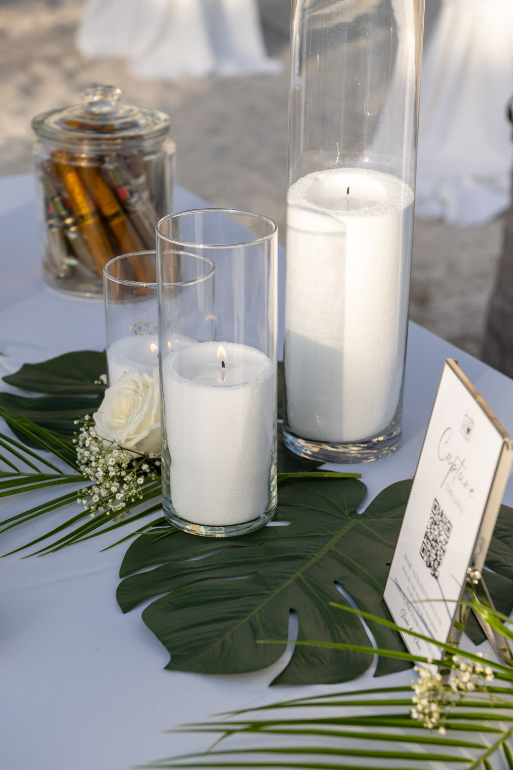 white candles on palm leaves on reception table