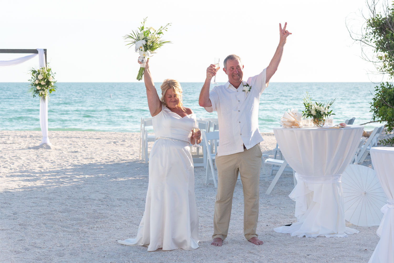 bride and groom raise their arms in celebration before grand entrance into their wedding reception