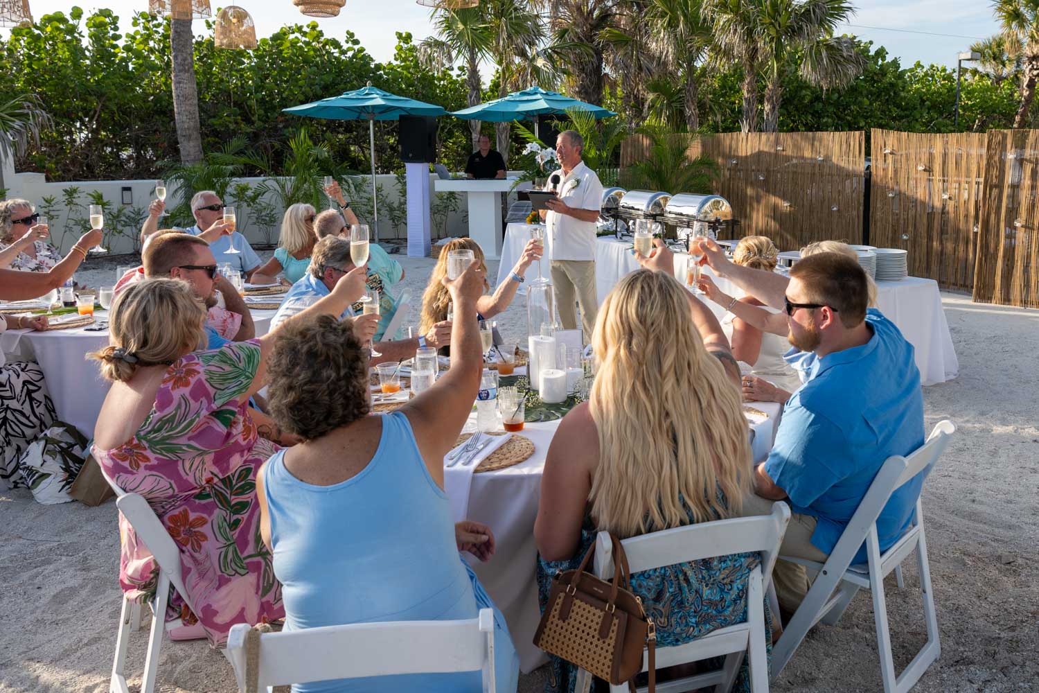 groom stands in front of their guests at the wedding reception to make a toast