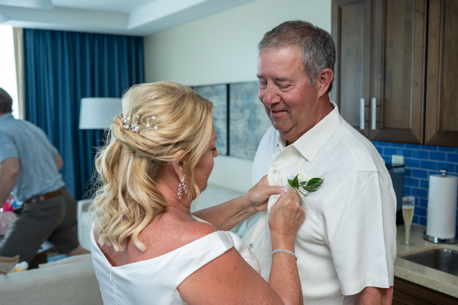 bride pinning on grooms boutonniere
