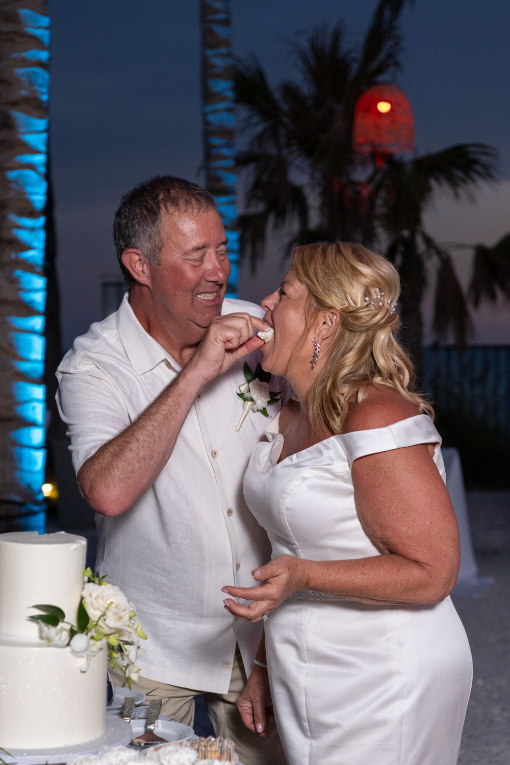 groom gently feeds his wife wedding cake