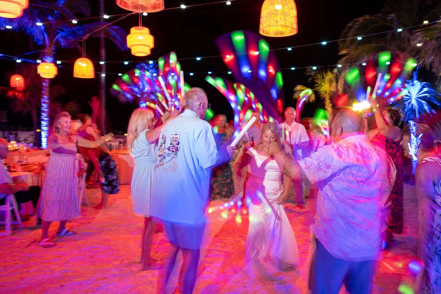 lanterns in the air and hand held colored lights by guests light up the dance floor as bride and guest get their dance moves on