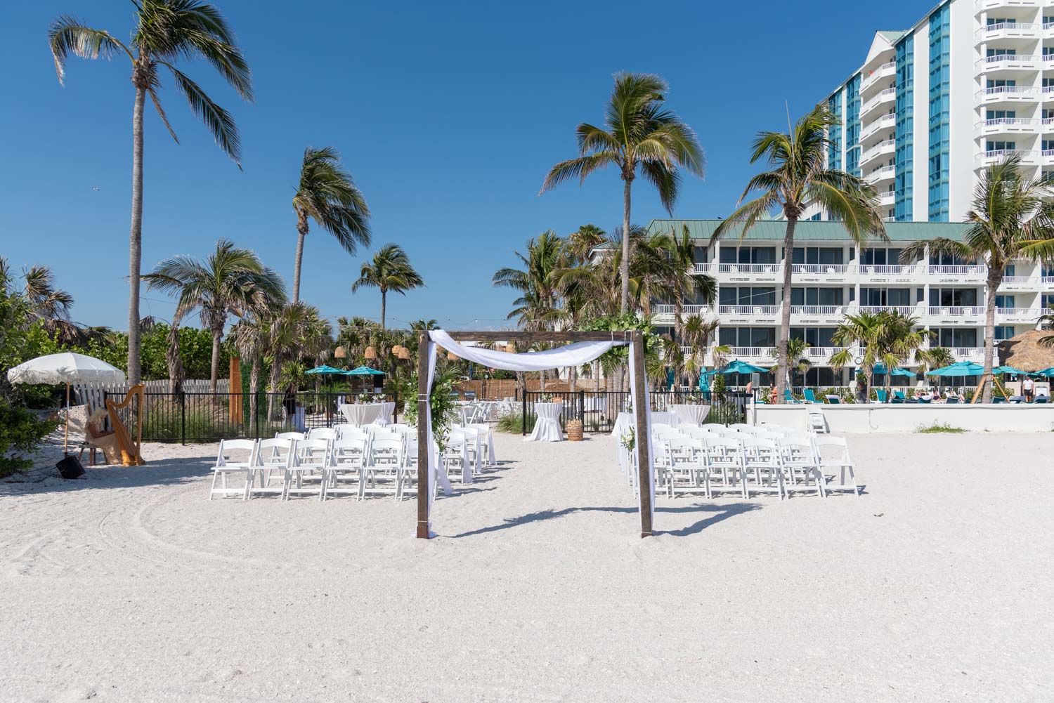 Lido Beach Resort wedding setup with arch and chairs and hotel in the background