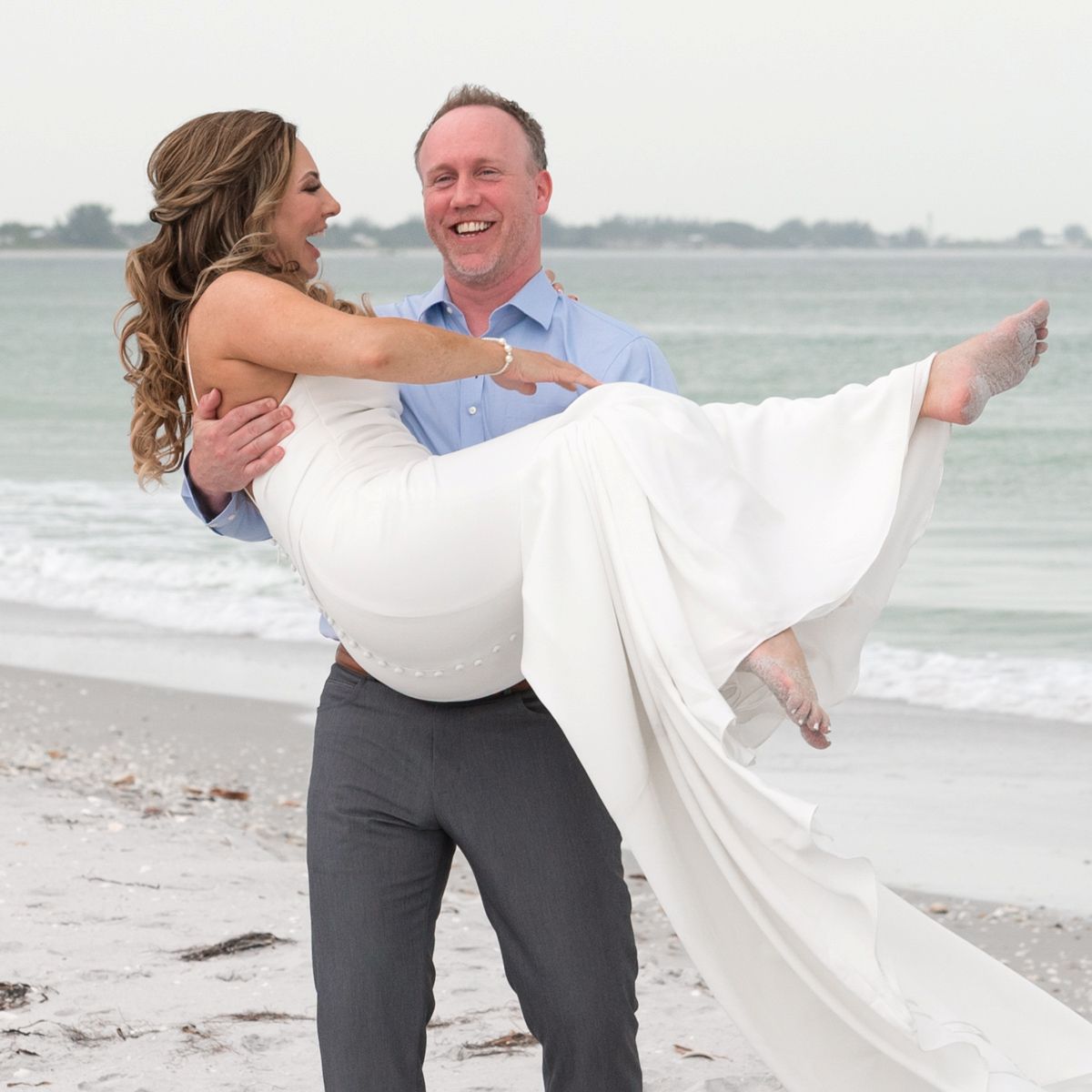 man twirls woman in air as she laughs