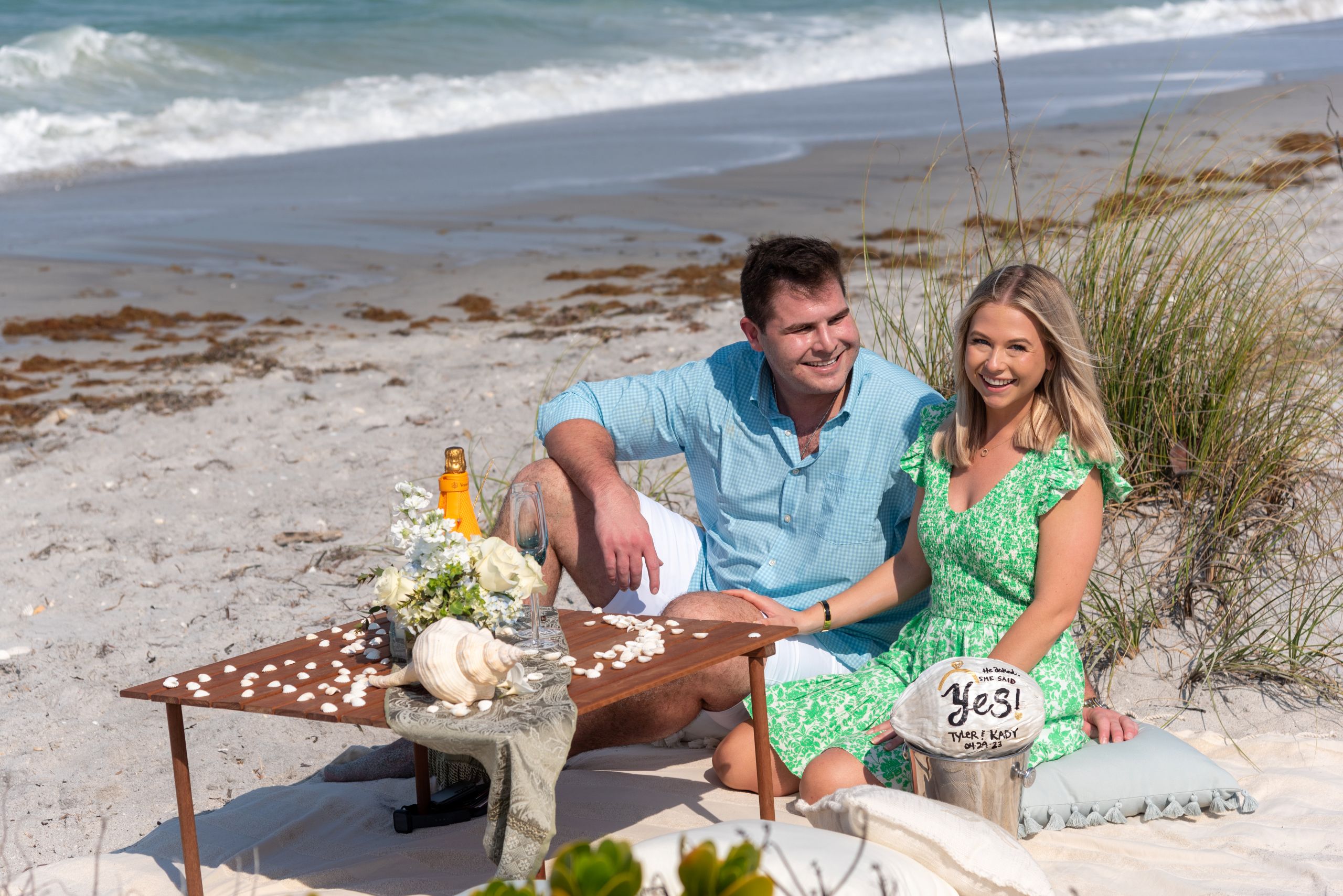 newly engaged couple sit down to enjoy their beach picnic after engagement on Palm Island