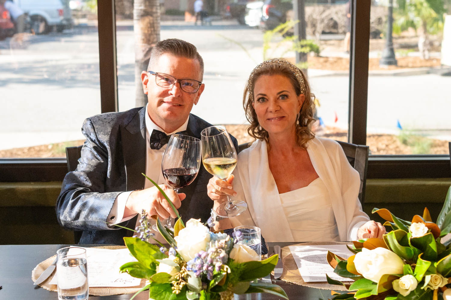 bride and groom toast with a glass of wine during wedding reception at Sage SRQ