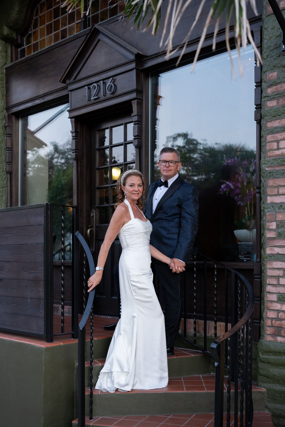 bride and groom on the steps outside Sage SRQ after their wedding