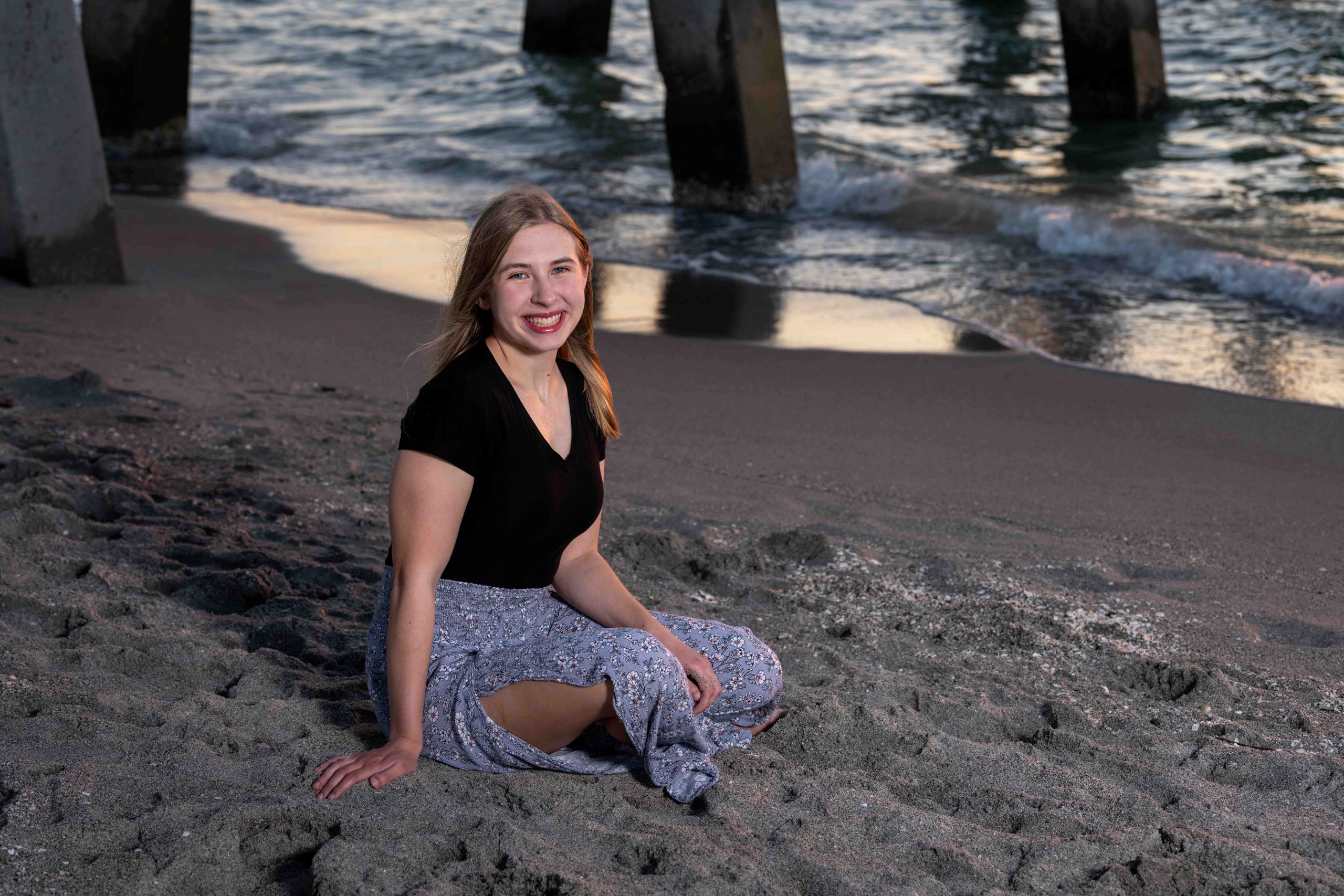 Senior photo of girl sitting on sand at the beach