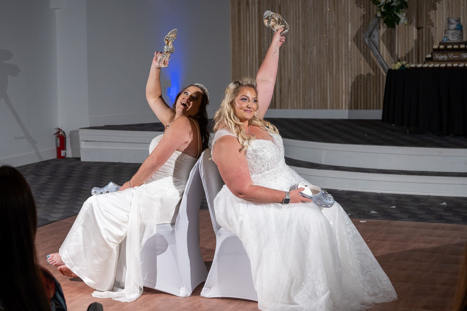 brides play shoe game at their wedding reception